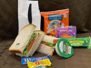 Ham Sandwich on Wheat Bread and Bagged Chips, Carrot Sticks with Buttermilk Ranch and Nature Valley Granola Bar. Comes with 1 Bottled Water.